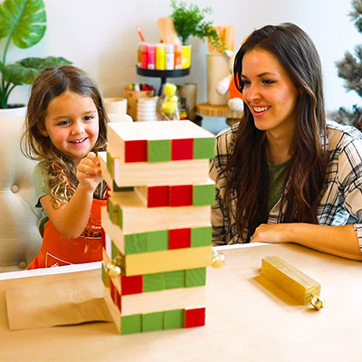 Mom and child playing with a DIY Holiday Toppling Tower.