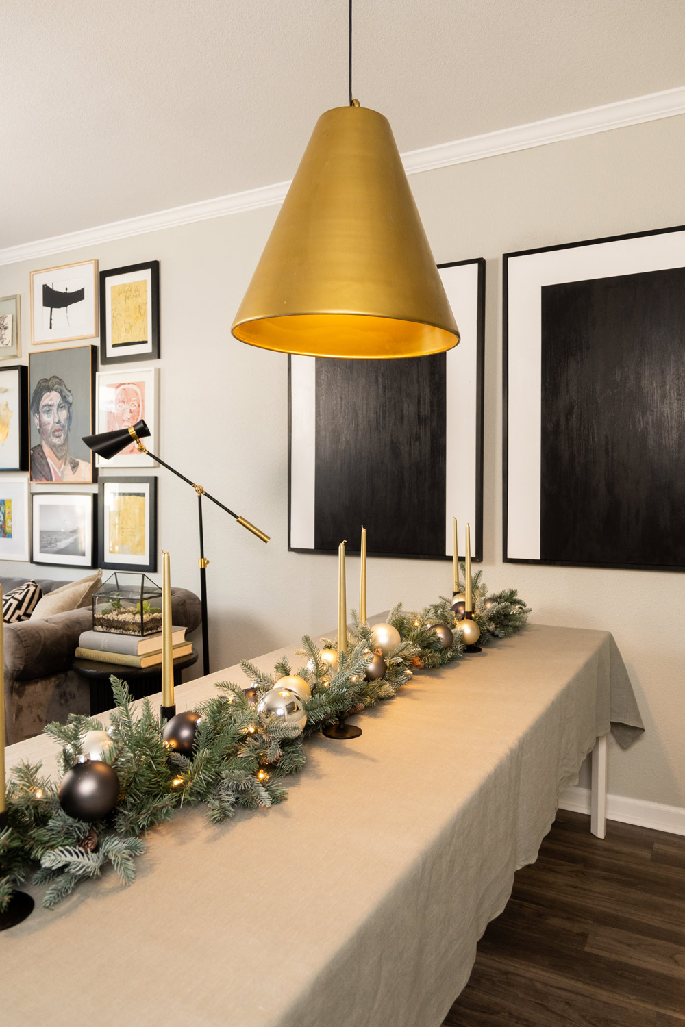 Holiday table setting in a dining room and a gold pendant light hanging above Holiday table setting in a dining room and a gold pendant light hanging above