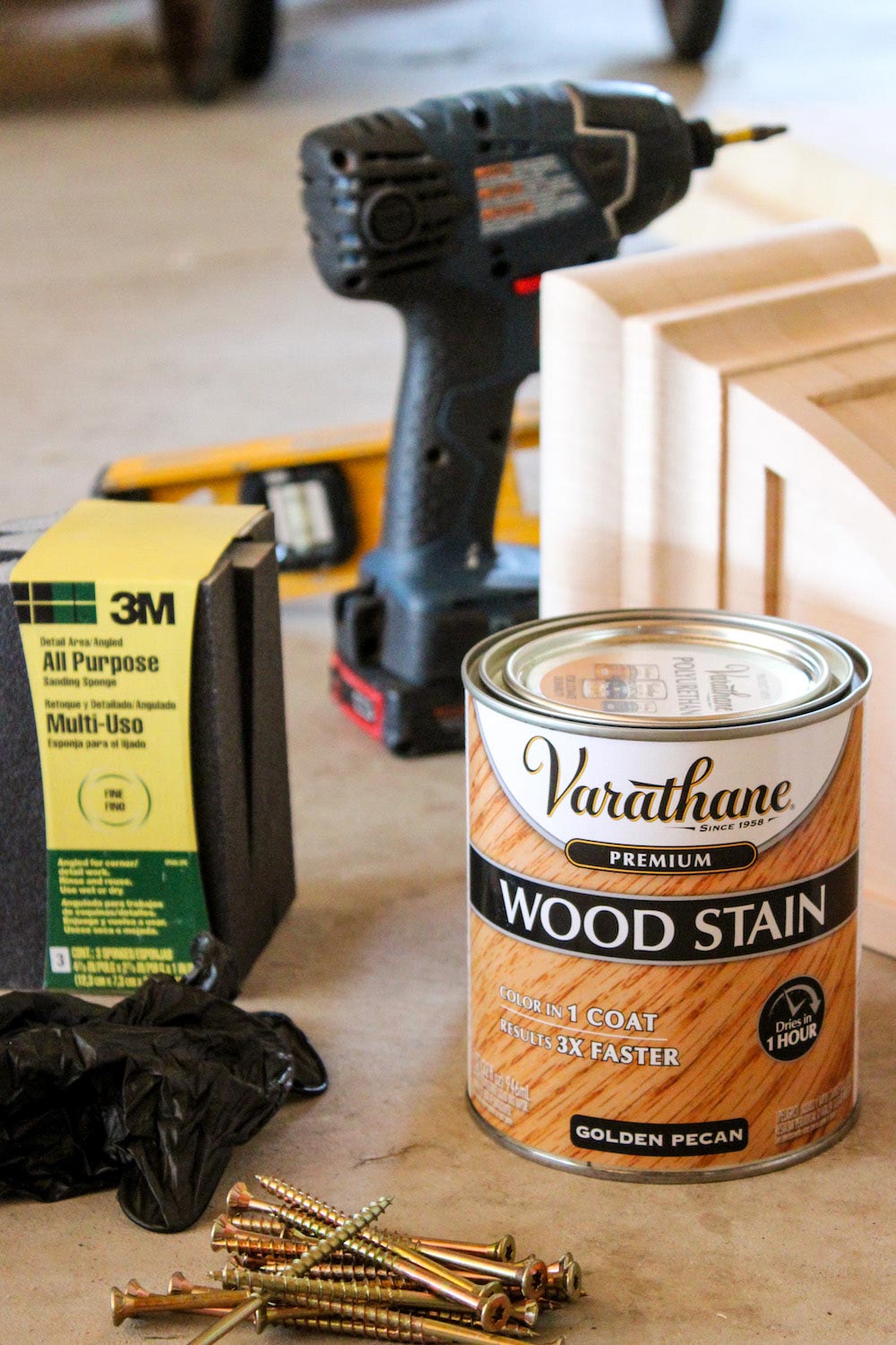 Various tools and materials needed to build and stain a wood shelf.