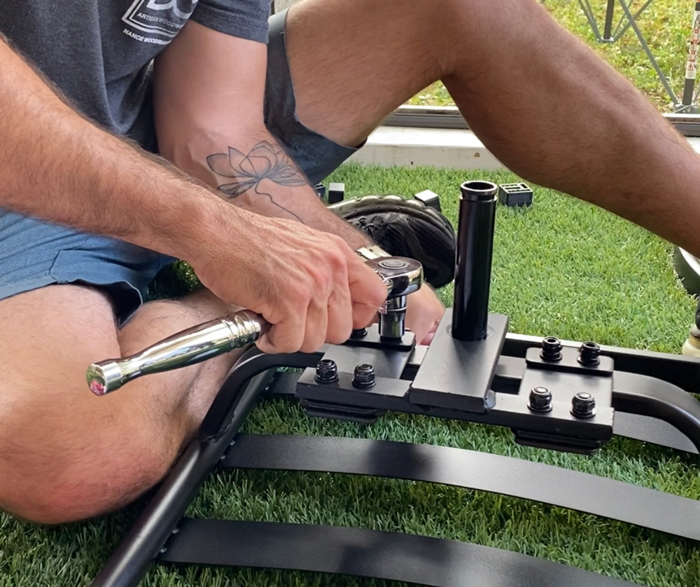 A man using a wrench on patio chair bolts. A man using a wrench on patio chair bolts.