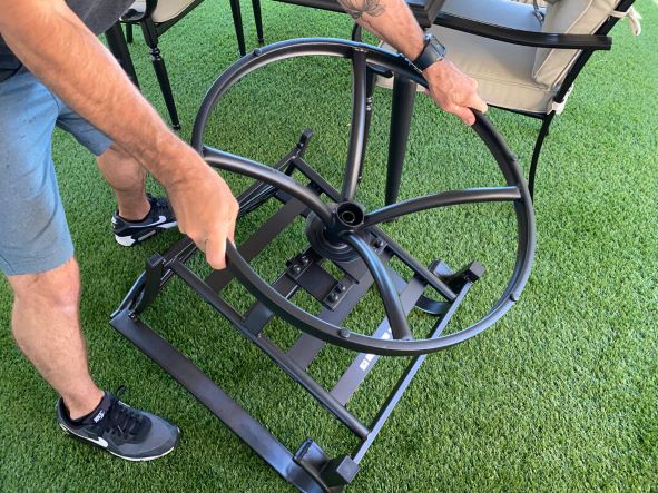 A man holding a swivel chair frame upside down. A man holding a swivel chair frame upside down.