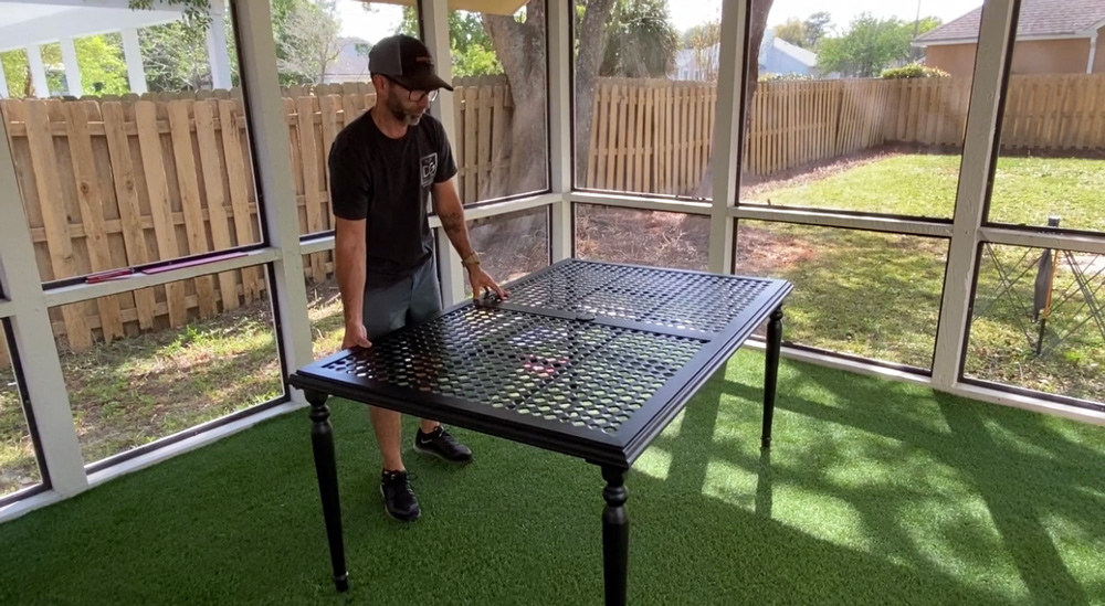 A man holding a table upright. A man holding a table upright.