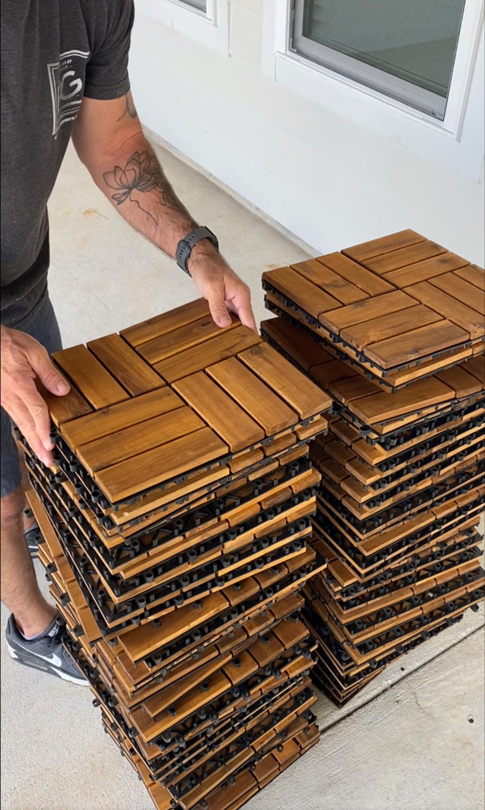A man holding a stack of wooden floor tiles. A man holding a stack of wooden floor tiles.
