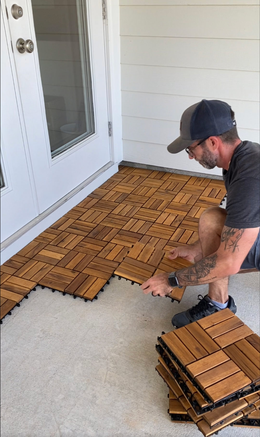 A man installing wooden floor panels to his patio floor. A man installing wooden floor panels to his patio floor.
