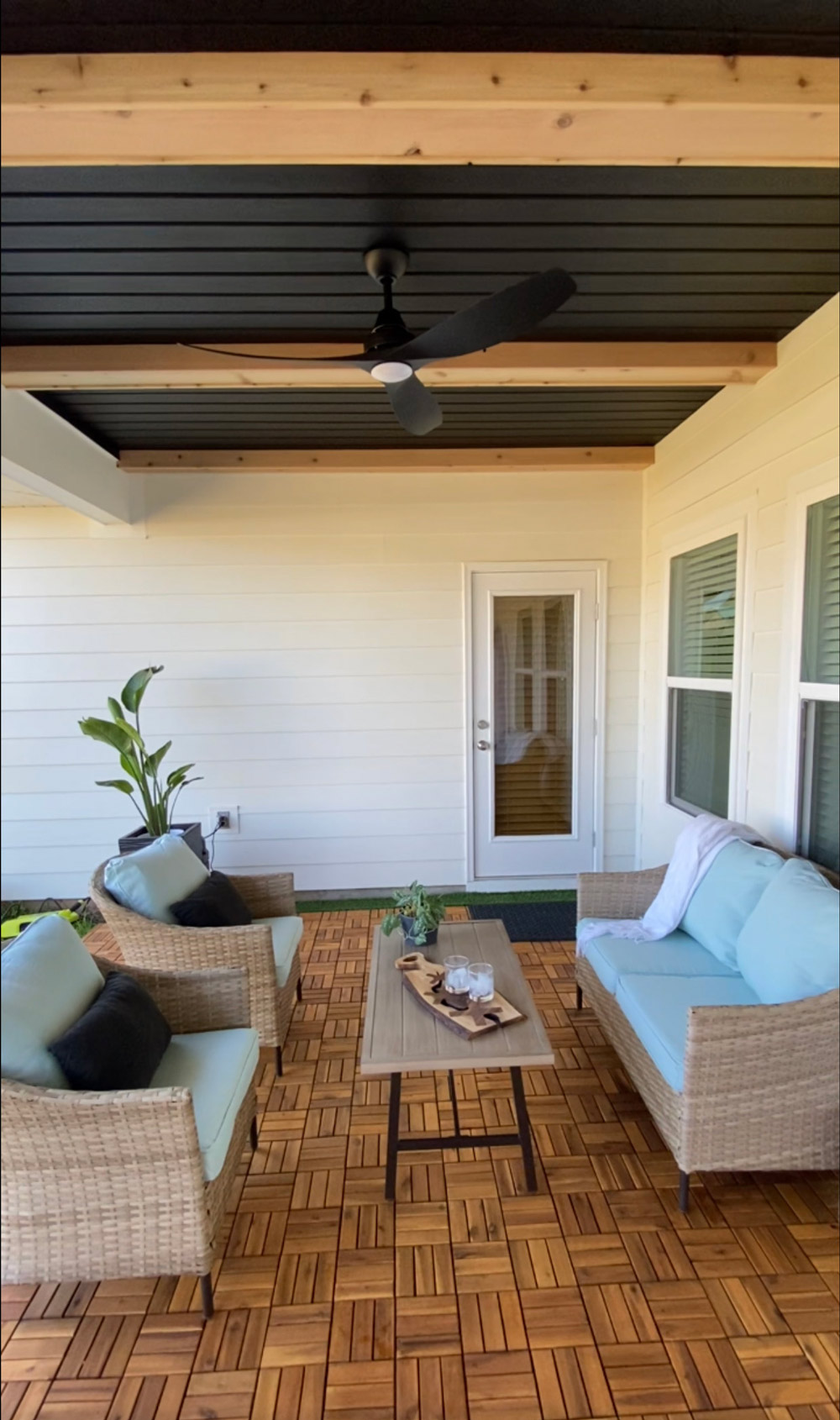 Completed patio space with a wicker patio set, wood panel flooring, and wood beam ceiling. Completed patio space with a wicker patio set, wood panel flooring, and wood beam ceiling.