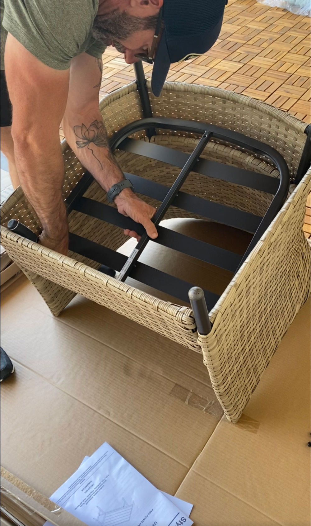 A man assembling a wicker patio chair. A man assembling a wicker patio chair.