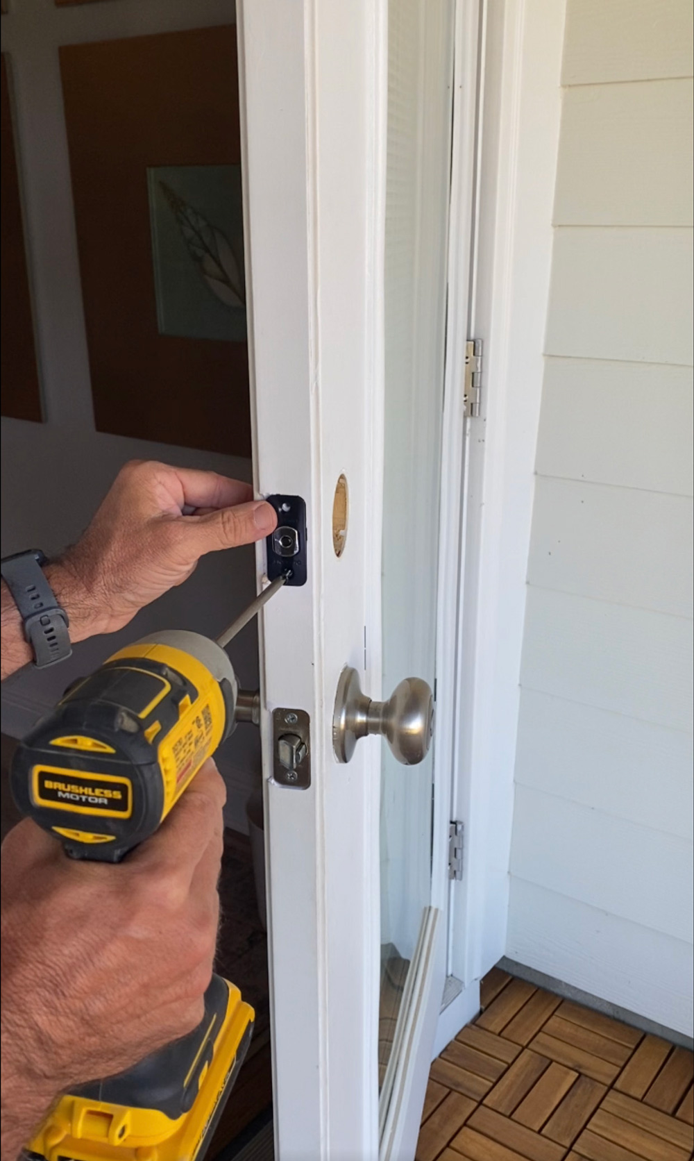 A man using a DeWalt drill to install a keypad lock. A man using a DeWalt drill to install a keypad lock.