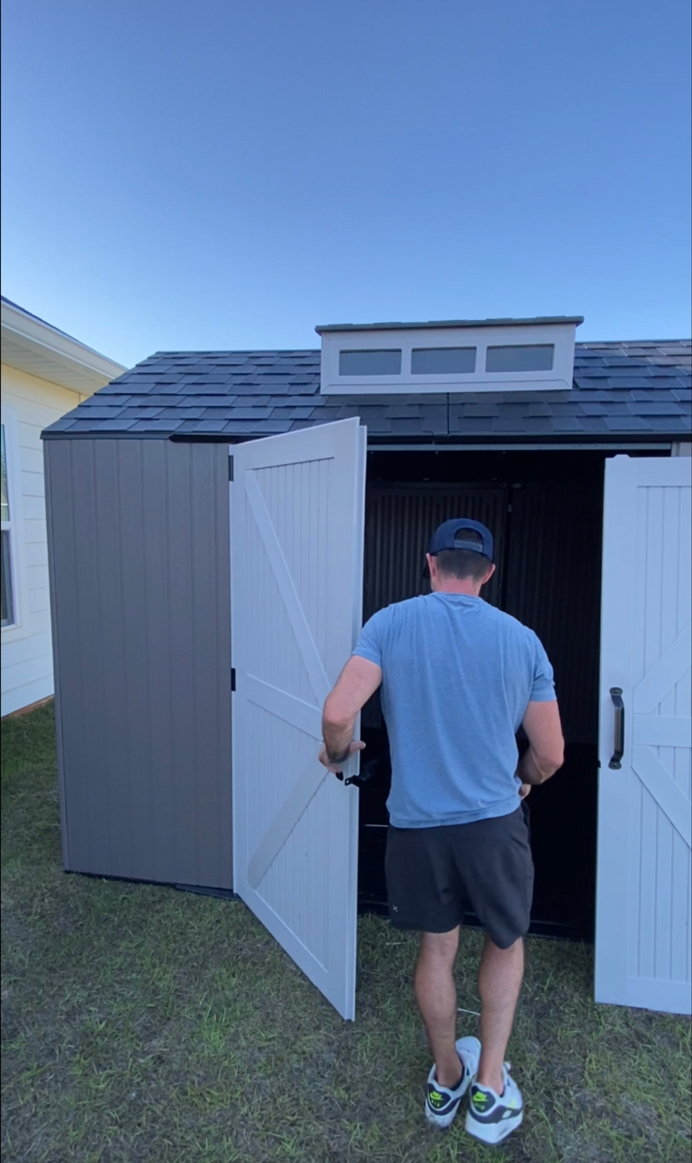 A man opening the door to an outdoor shed. A man opening the door to an outdoor shed.