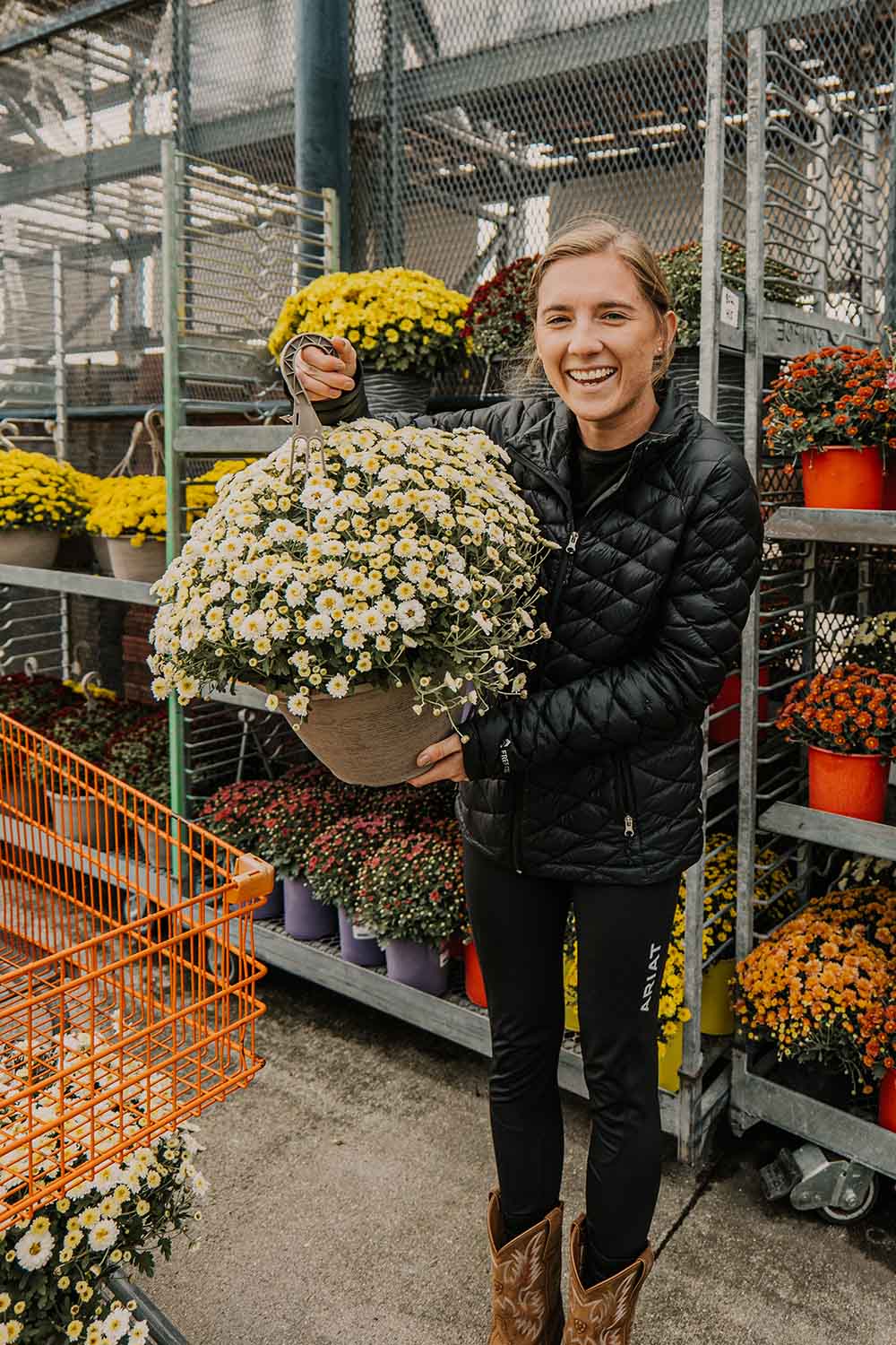 A woman holding a plant in the garden section of The Home Depot. A woman holding a plant in the garden section of The Home Depot.