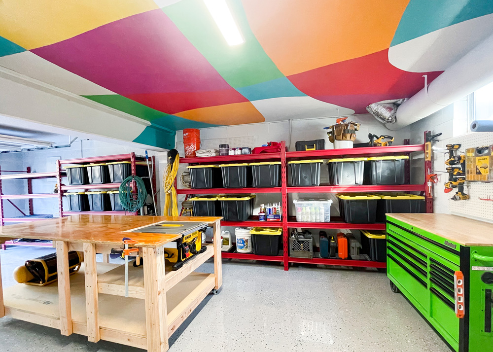 Garage remodeled and red shelves with black bins and yellow tops under the colorful ceiling. Garage remodeled and red shelves with black bins and yellow tops under the colorful ceiling.