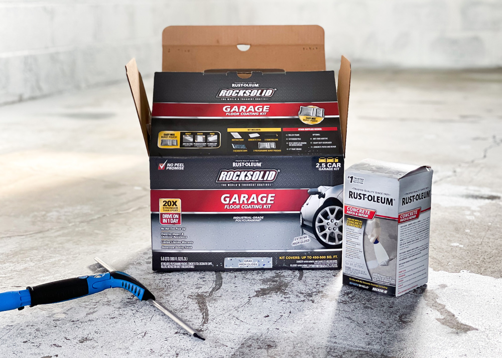 Open box of garage floor coating kit on the garage floor. Open box of garage floor coating kit on the garage floor.