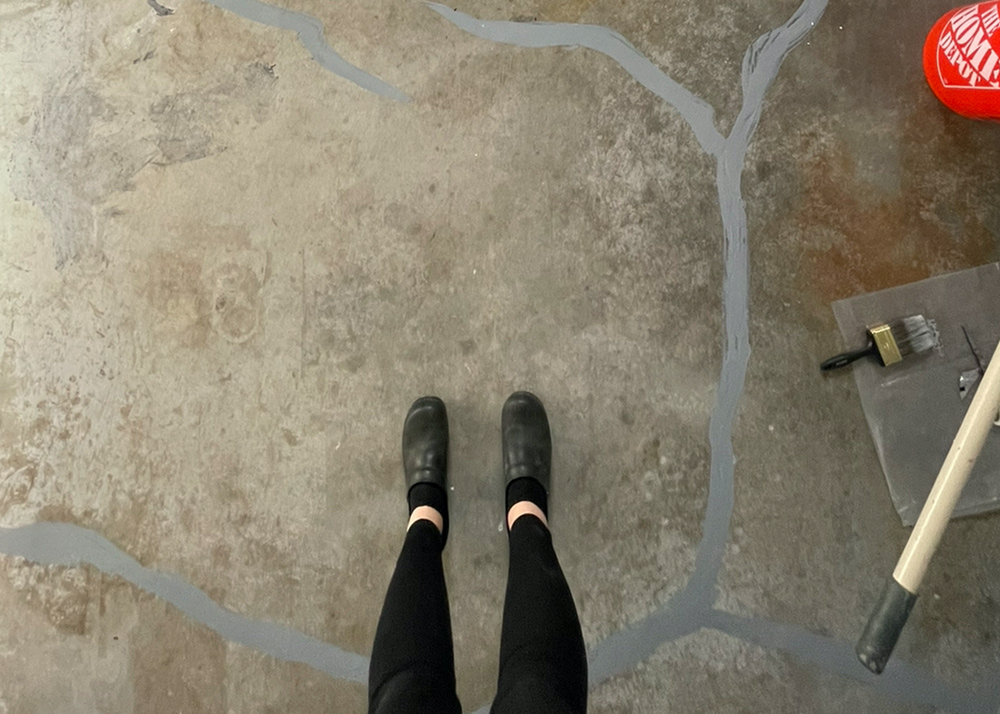 Above view of legs standing on the non-renovated garage floor. Above view of legs standing on the non-renovated garage floor.