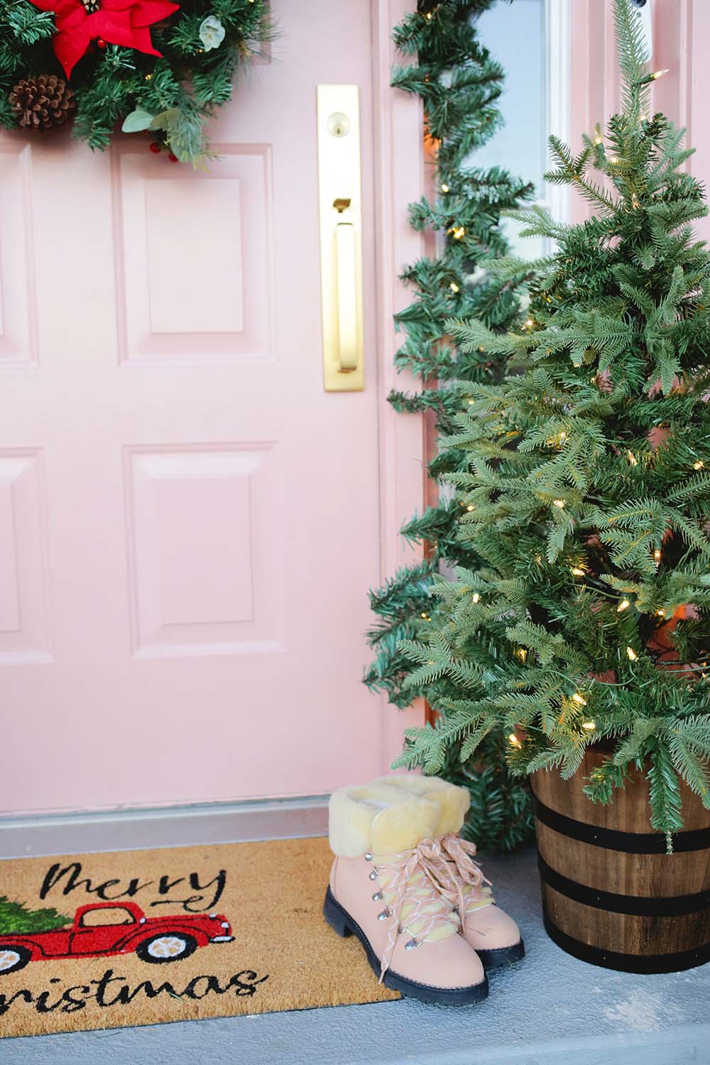 A closeup shot of the small Christmas tree and decorated front door.