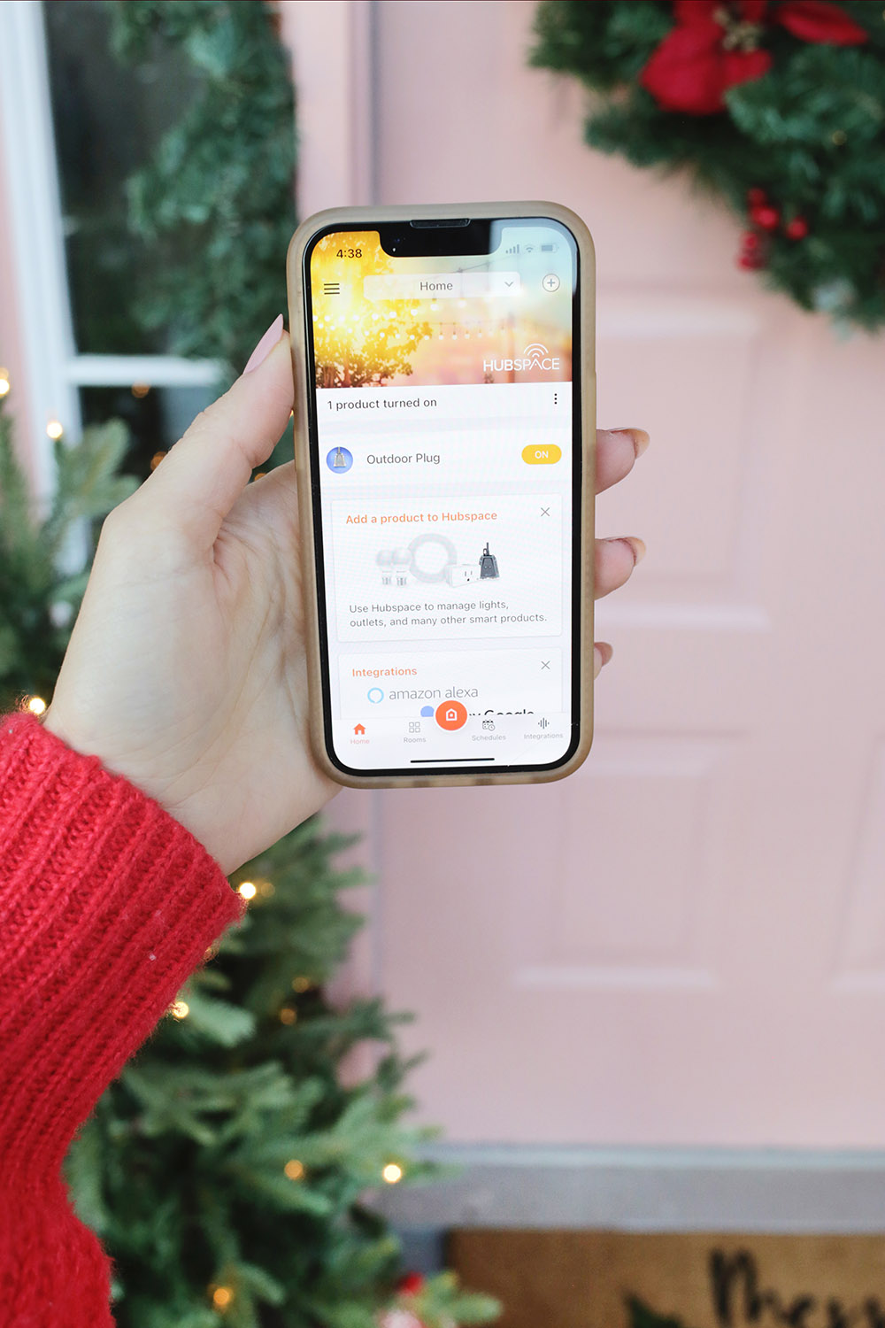 A photo of someone using the HubSpace app on their phone outside their front door.