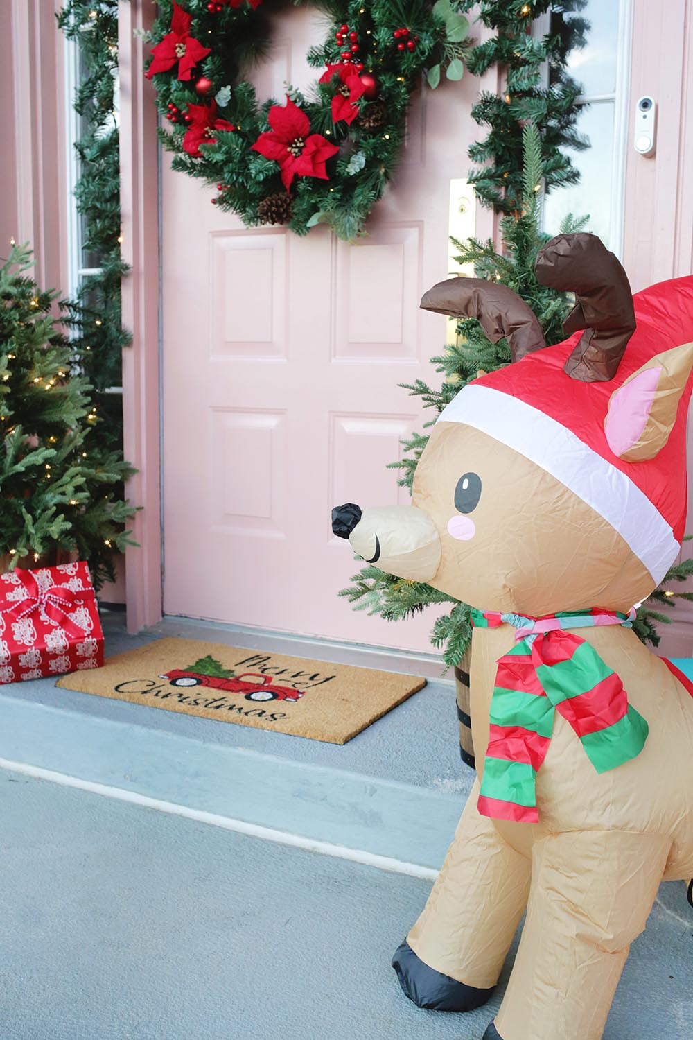 A shot of the decorated front door featuring an inflatable reindeer.
