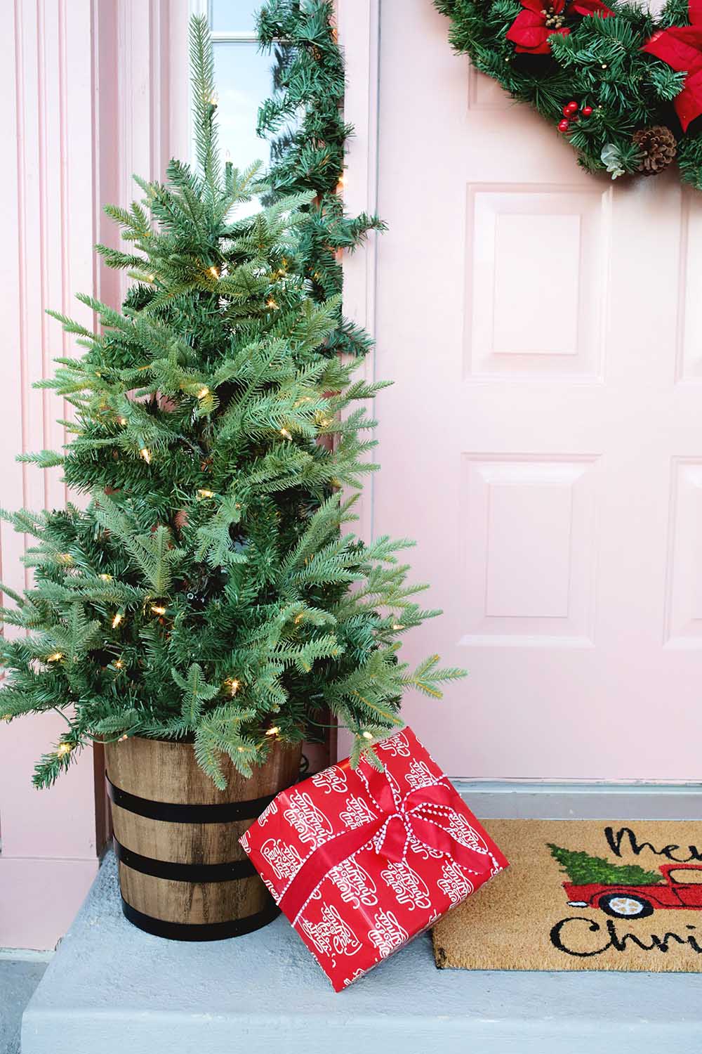 A small lit Christmas tree sitting next to the front door.