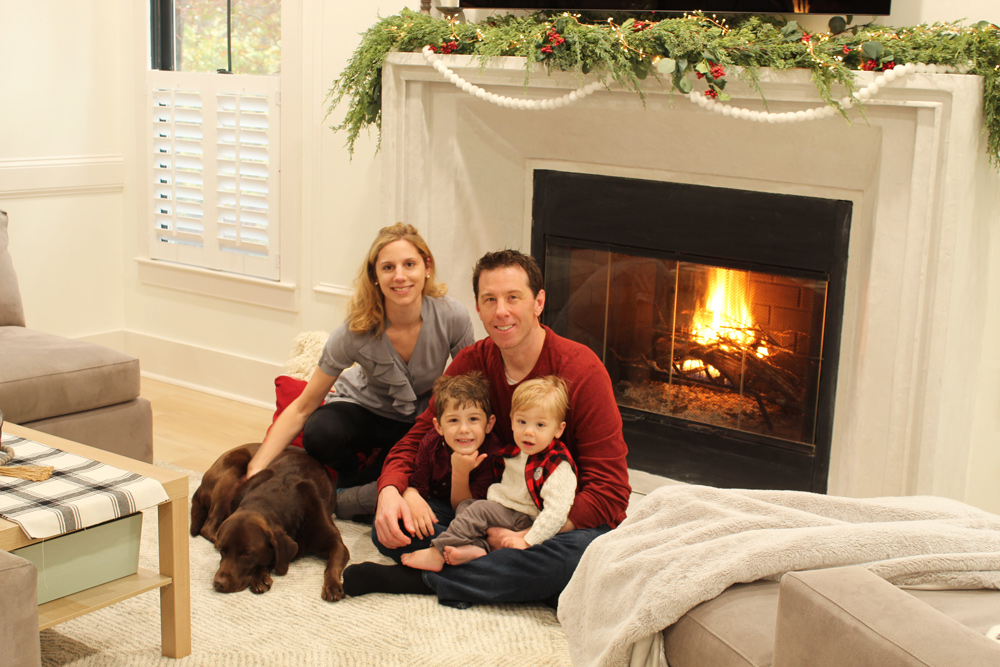 Family and dog sitting in front of upgraded fireplace.