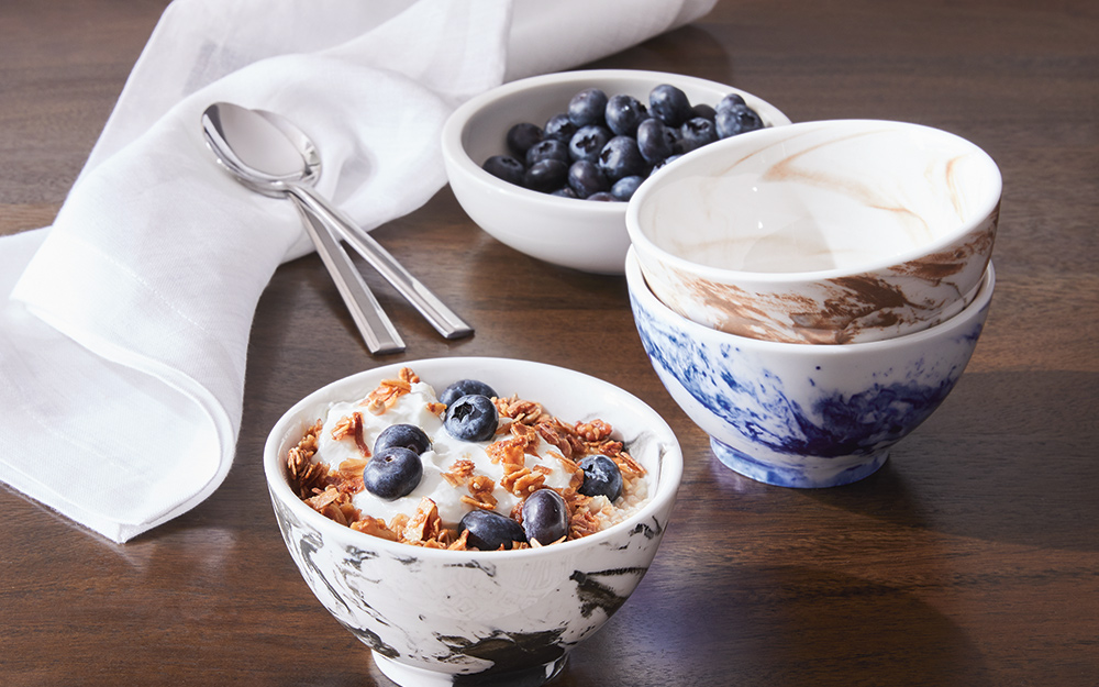 A white napkin on a table with cereal bowls and spoons A white napkin on a table with cereal bowls and spoons
