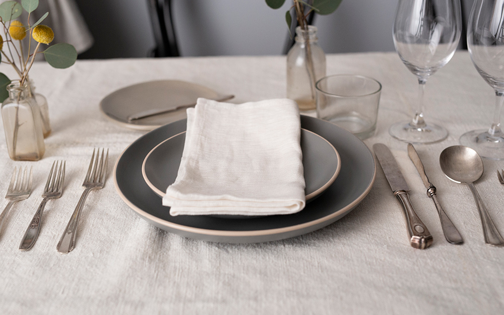 A formal place setting with the napkin on top of the plate.