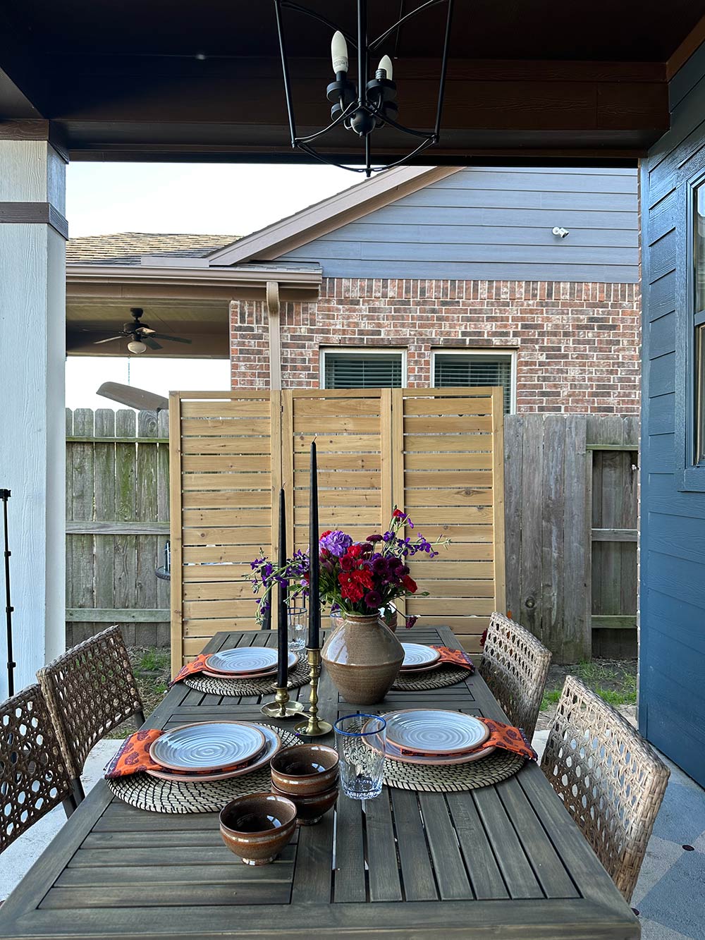 A tablescape of a table with four chairs, flowers and two candles. A tablescape of a table with four chairs, flowers and two candles.
