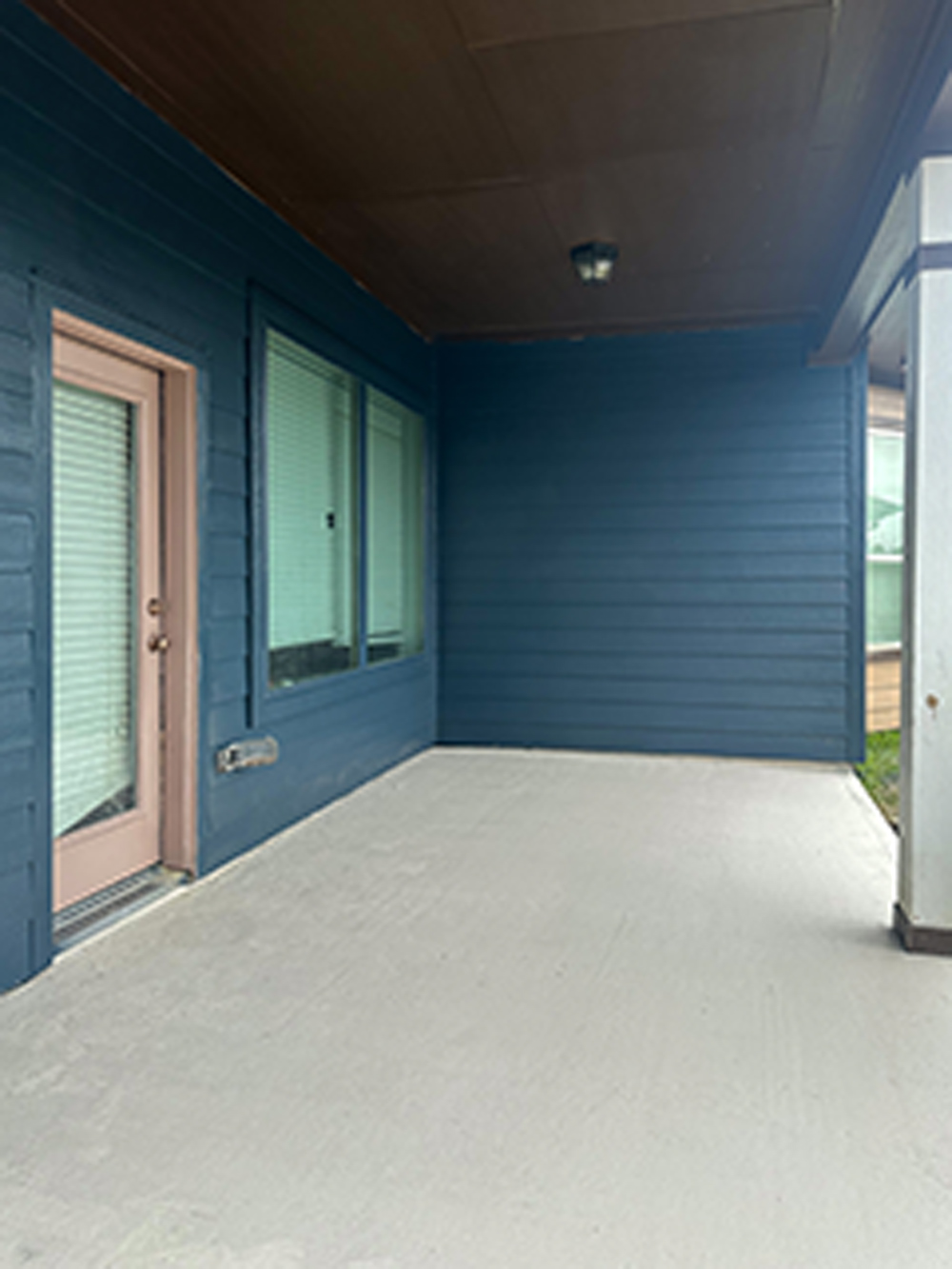 An empty back patio outside a blue house. An empty back patio outside a blue house.