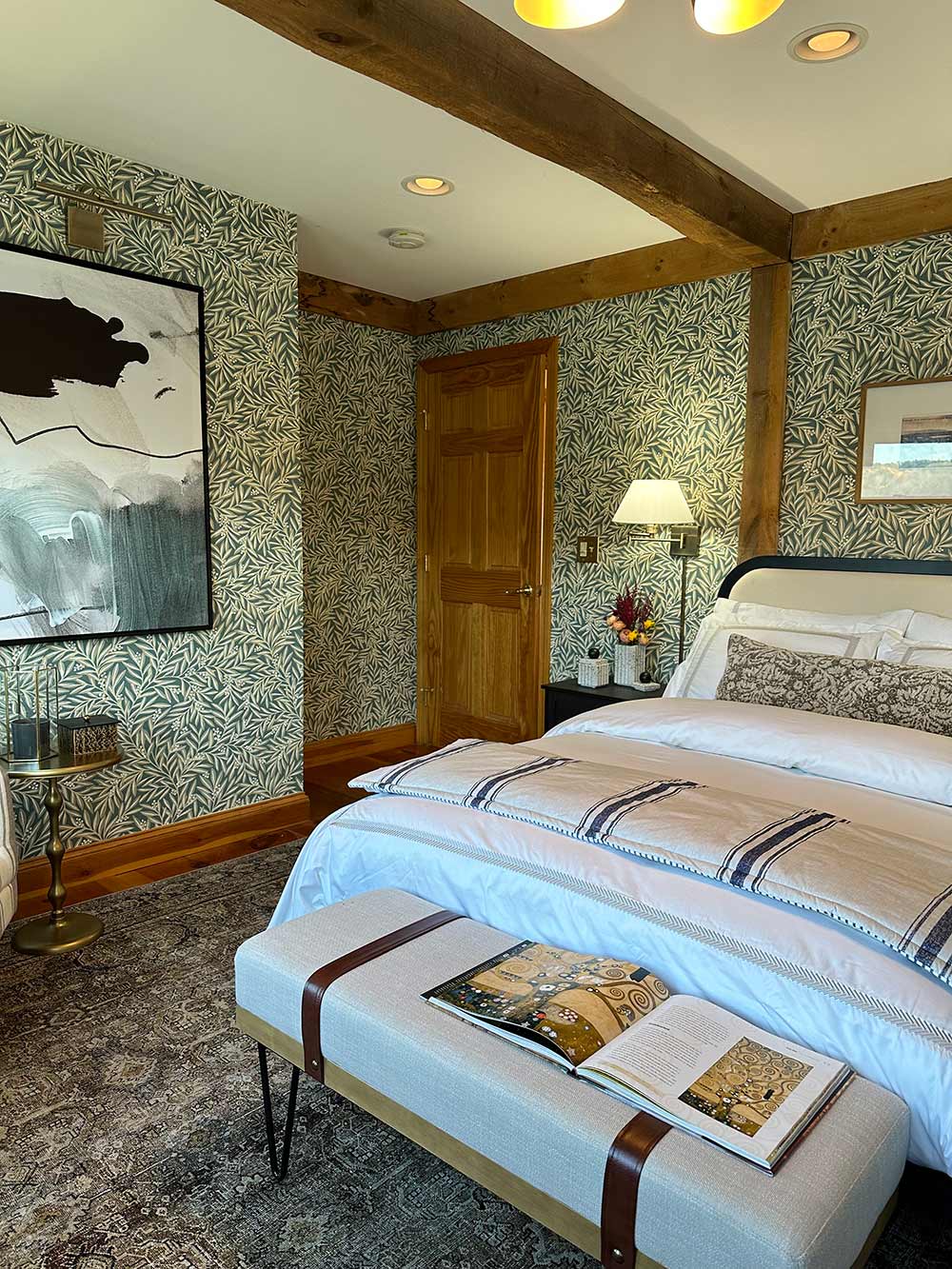 A full bed in a bedroom with green and white pattern wallpaper. A full bed in a bedroom with green and white pattern wallpaper.