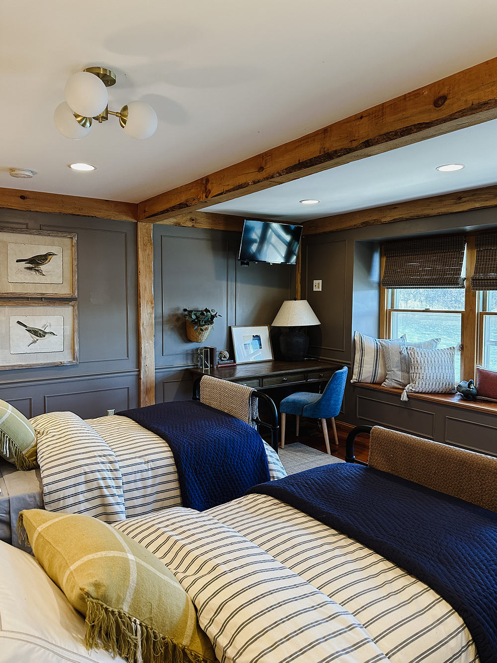 Two twin beds with blue and white bedding and a wooden desk. Two twin beds with blue and white bedding and a wooden desk.