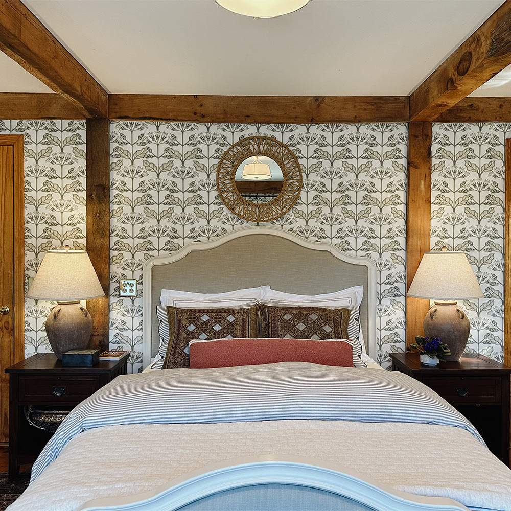 A white bed with white and grey pattern wallpaper and matching side tables. A white bed with white and grey pattern wallpaper and matching side tables.