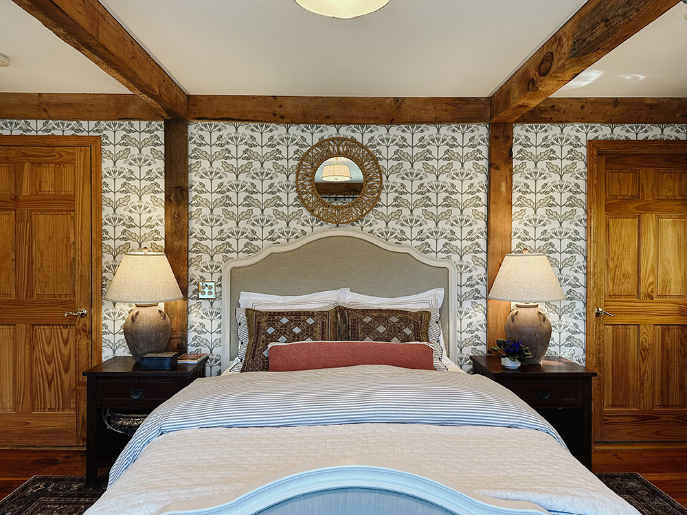 A white bed with white and grey pattern wallpaper and matching side tables. A white bed with white and grey pattern wallpaper and matching side tables.