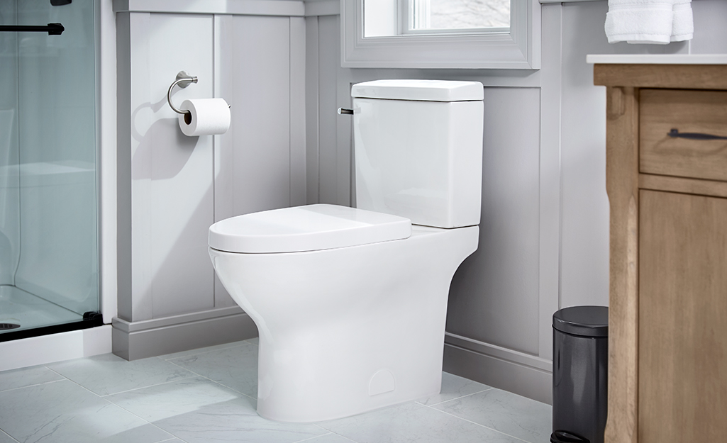 A Glacier Bay toilet installed in a small bathroom.