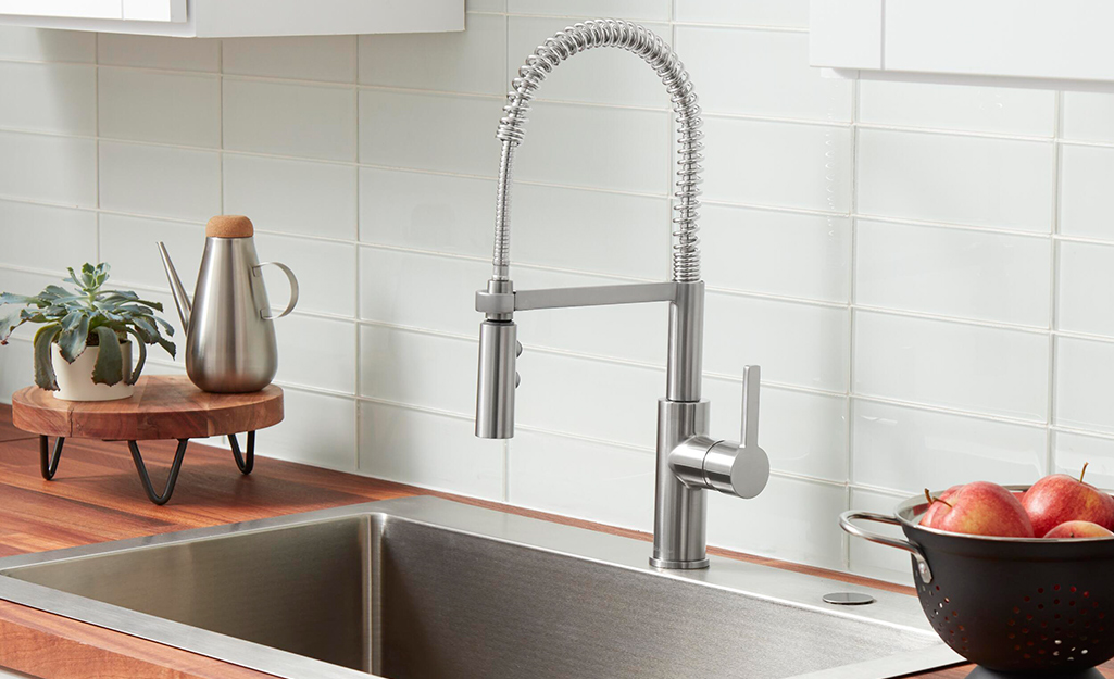 A stainless kitchen sink featuring a Glacier Bay faucet.