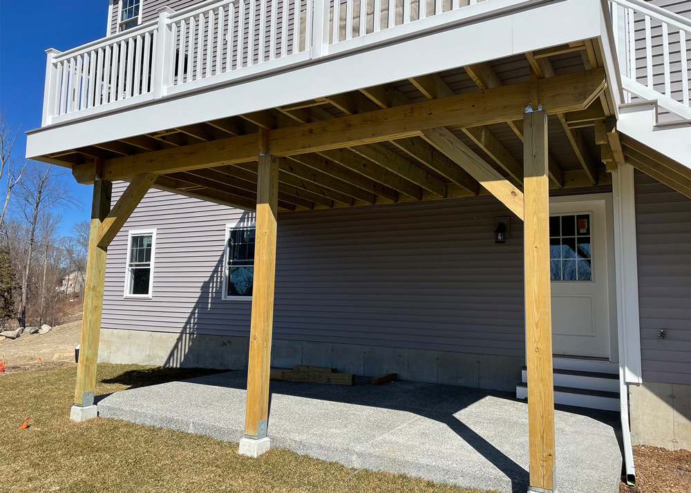 A backyard patio under contraction with wooden beam supports