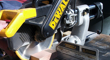 A person uses a saw to cut a board. A person uses a saw to cut a board.