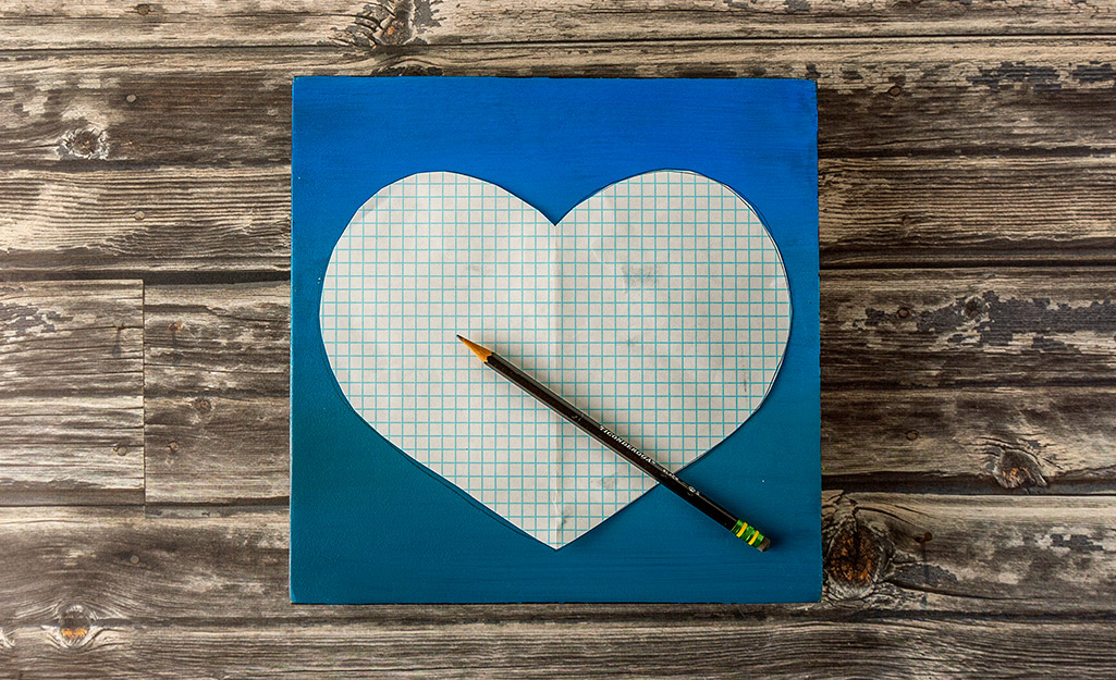 A piece of wood with a paper heart on top of it.