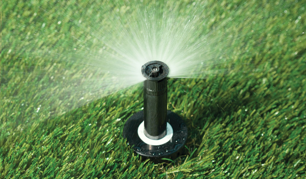 A nozzle sprinkler waters a lawn.