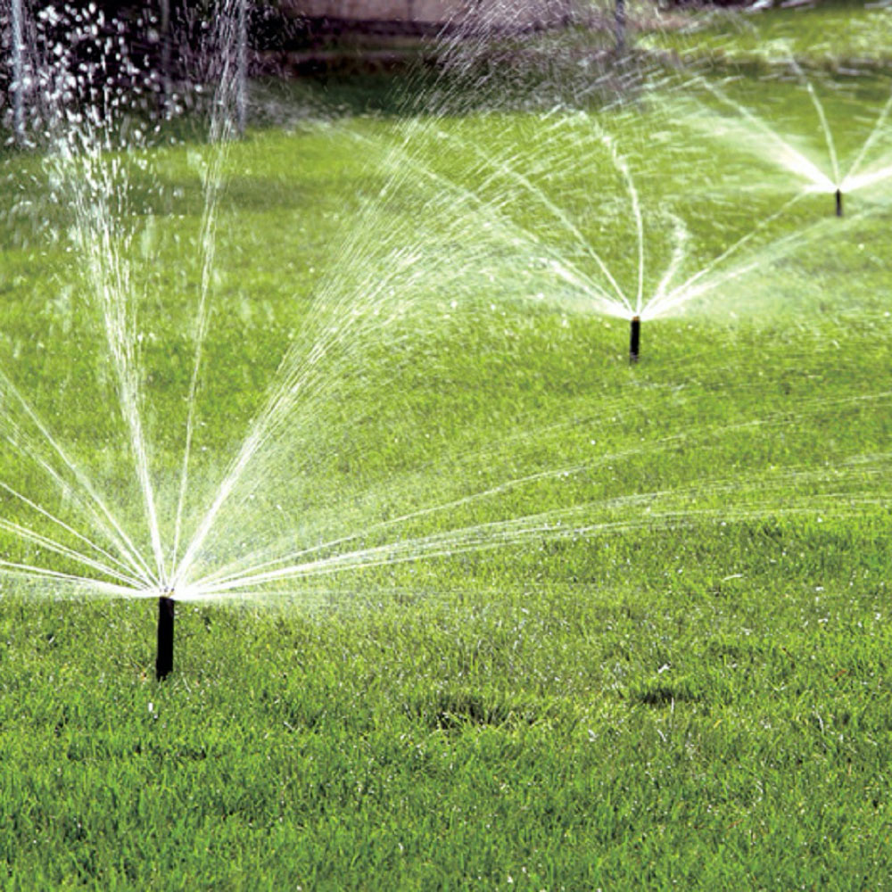 Sprinkler heads water a lawn.