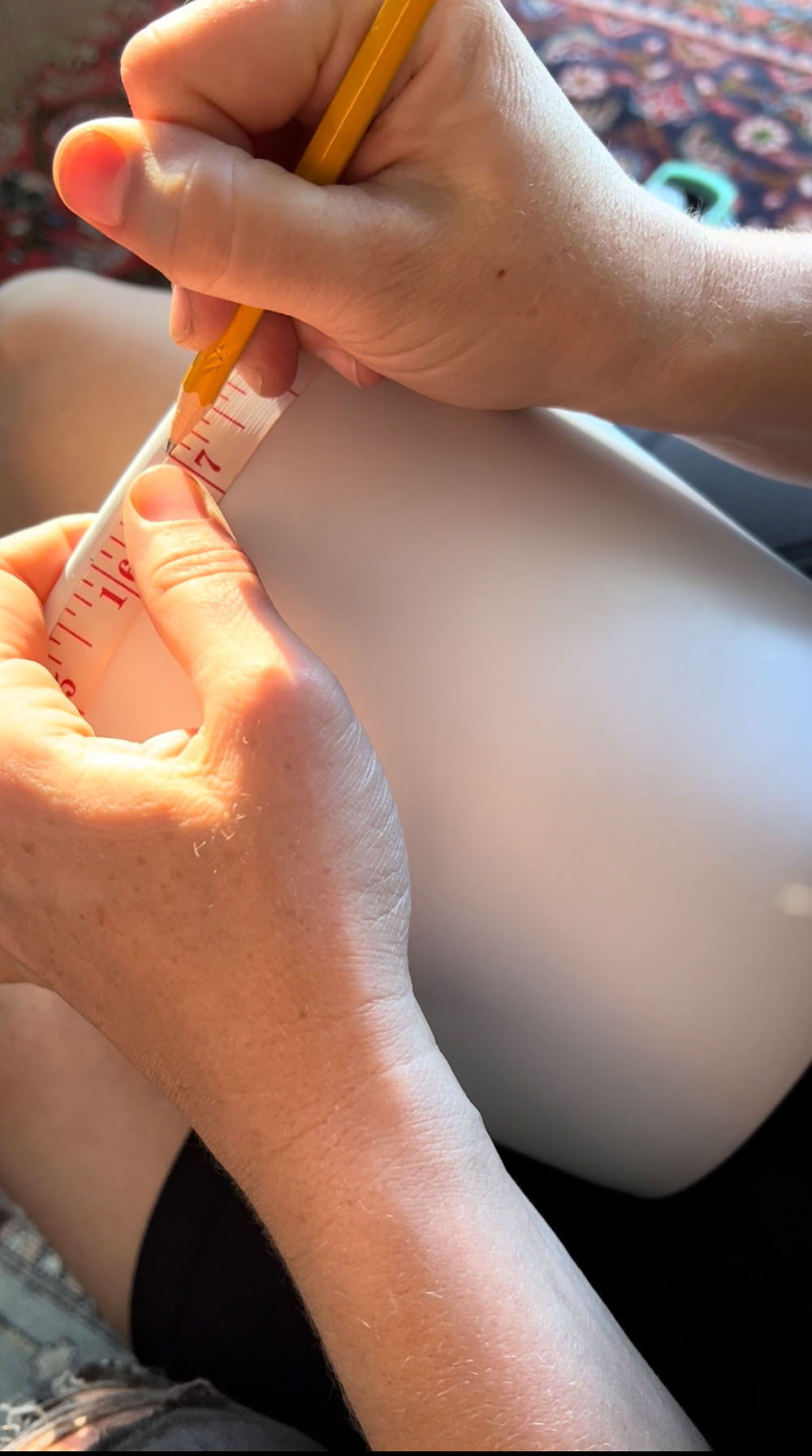 A white planter pot with a hand measuring for spacing of lines.