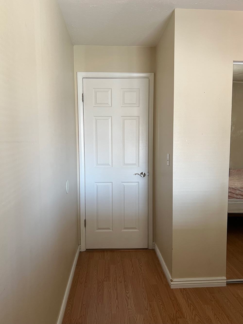 A white door in a beige room.