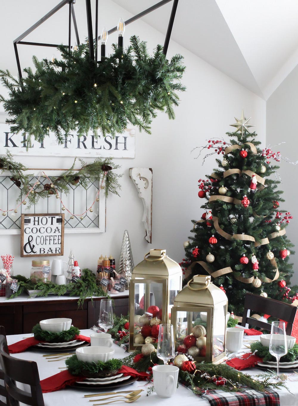 Angled shot of a holiday decorated dining room with a Christmas tree in the back corner