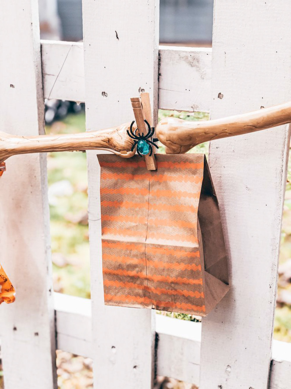 A trick-or-treat bag hanging on a fence.