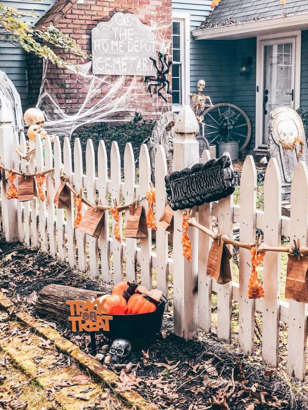 The outside of a ghostly graveyard lined with trick-or-treat bags.
