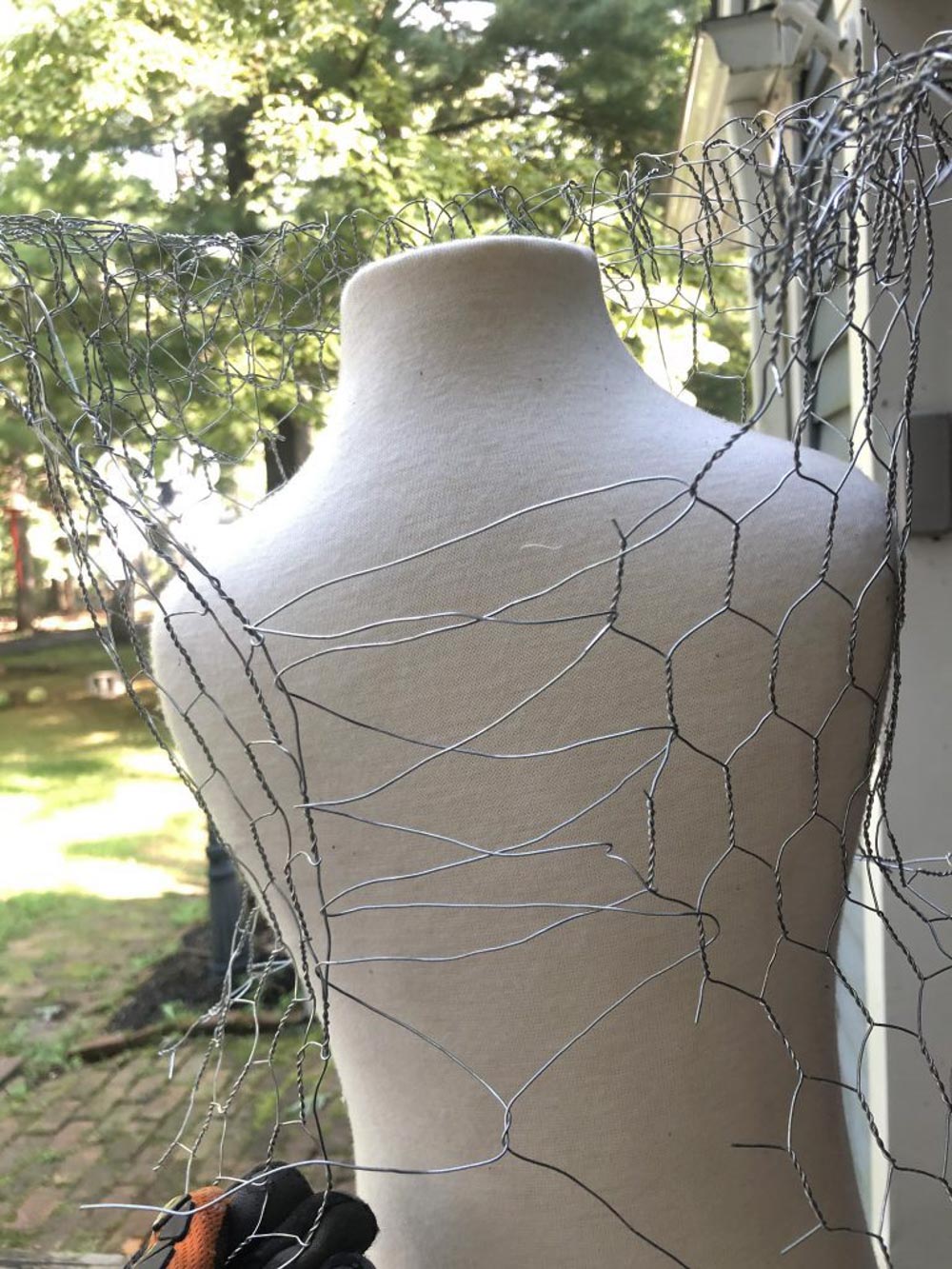 A mannequin wrapped in chicken wire.