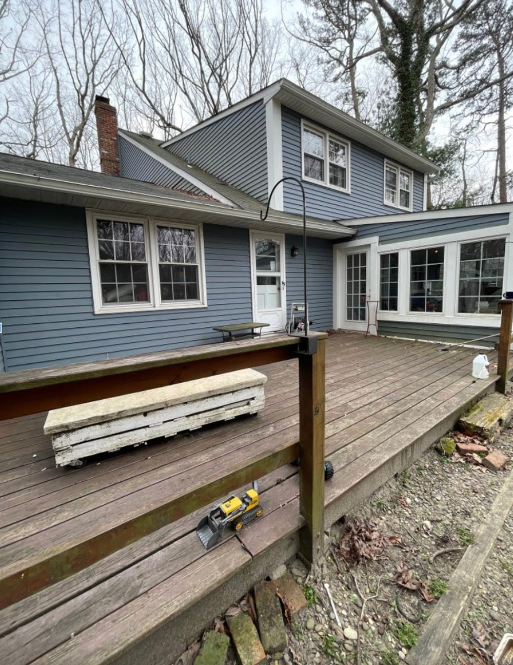 Blue house with run down wood deck. 