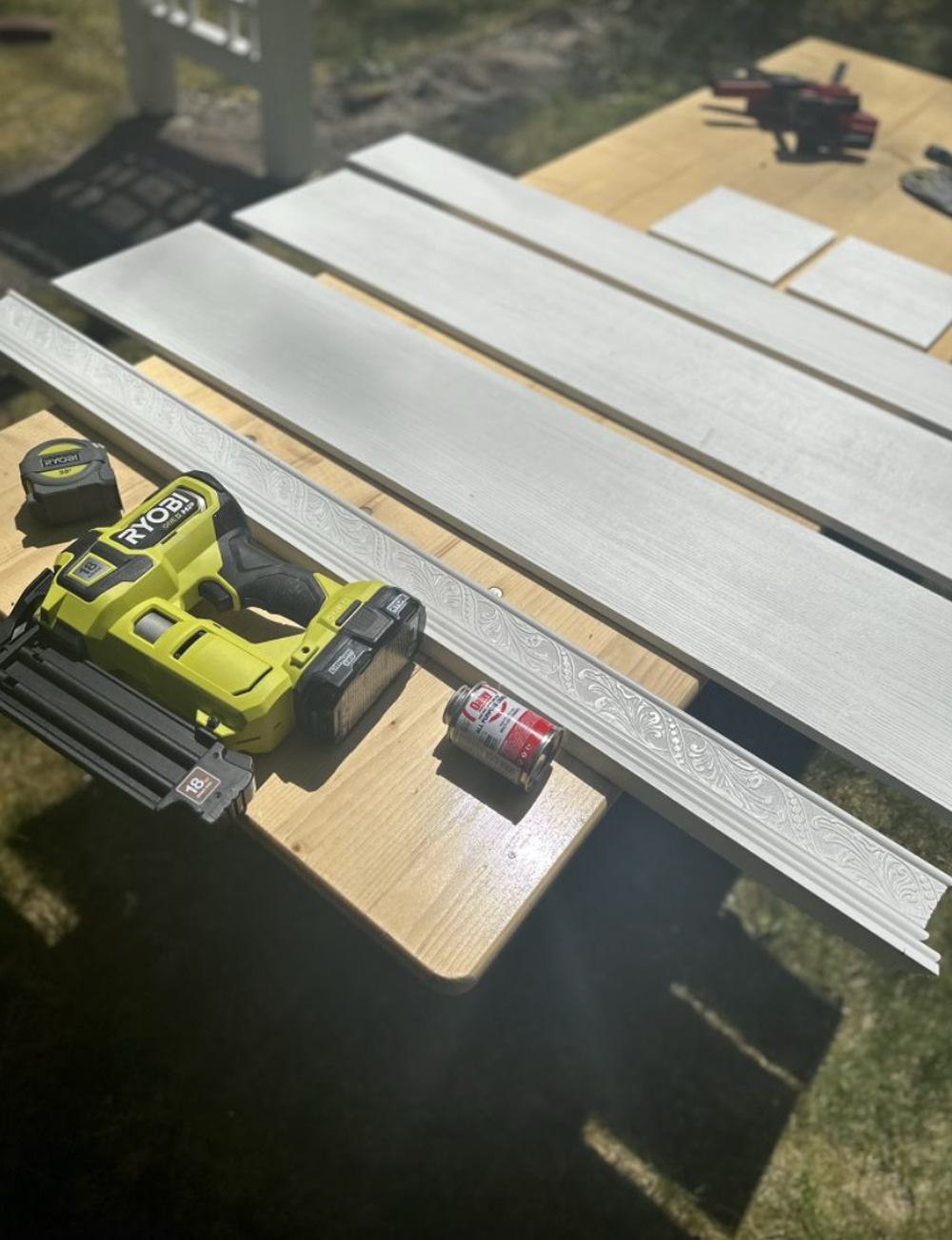 Sheets of PVC laid on wood table with Ryobi tools. 