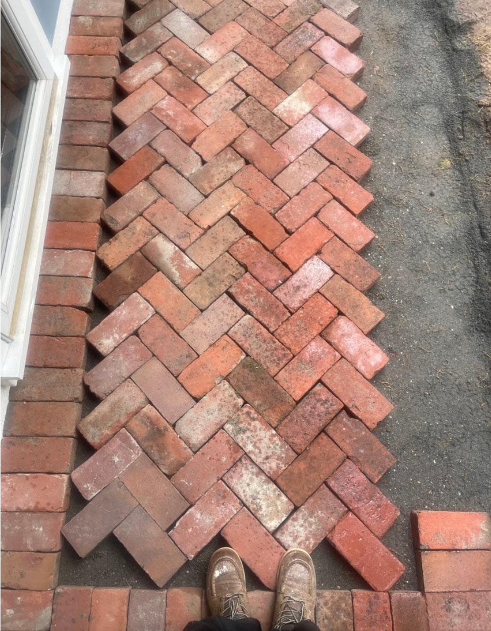 Bricks laid on the ground in a zig zag pattern. 