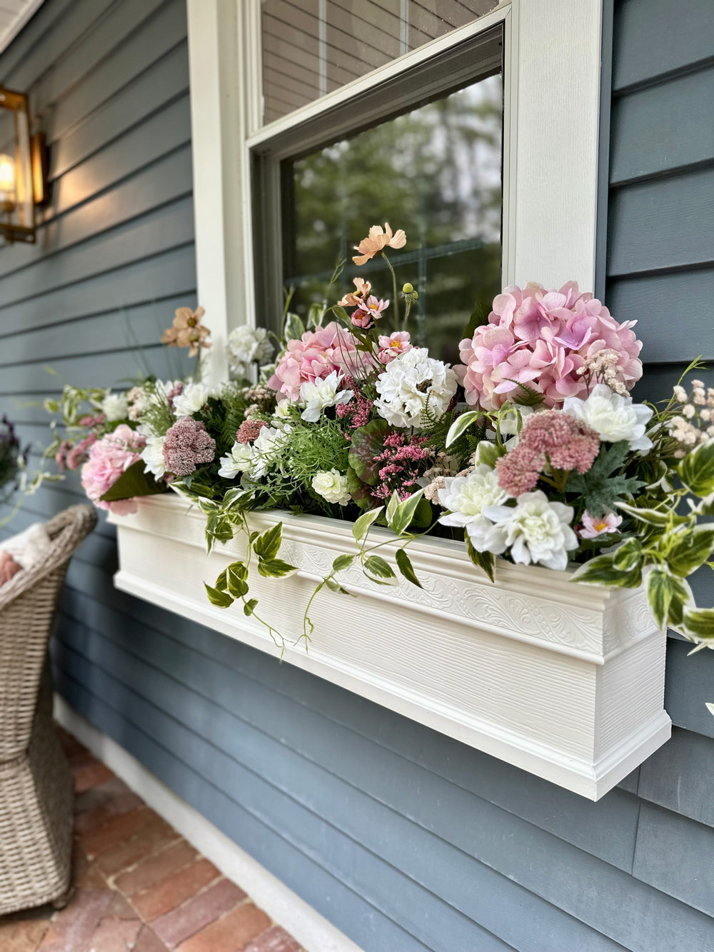 White window planted filled with pink and white flowers. 