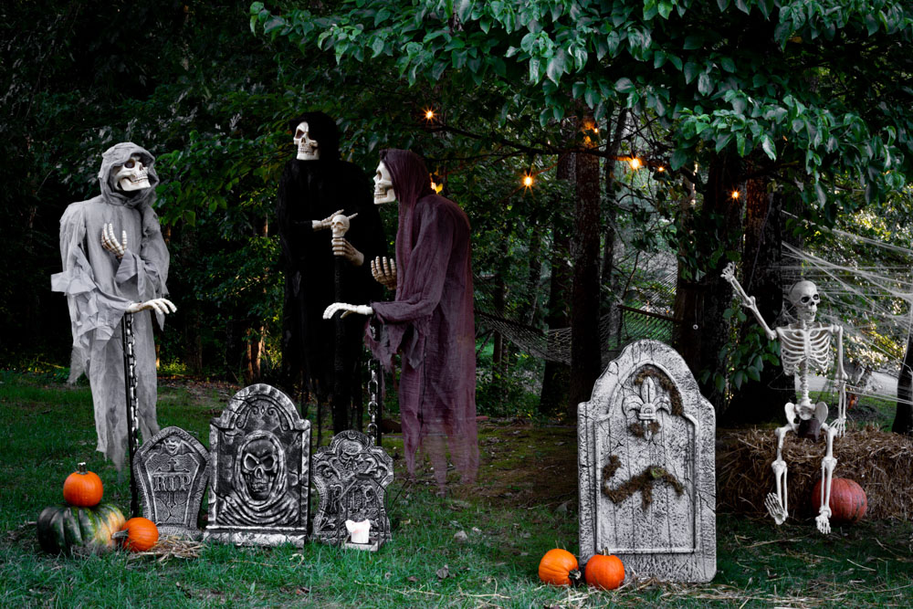A group of grim reapers floating above tombstones in a graveyard.