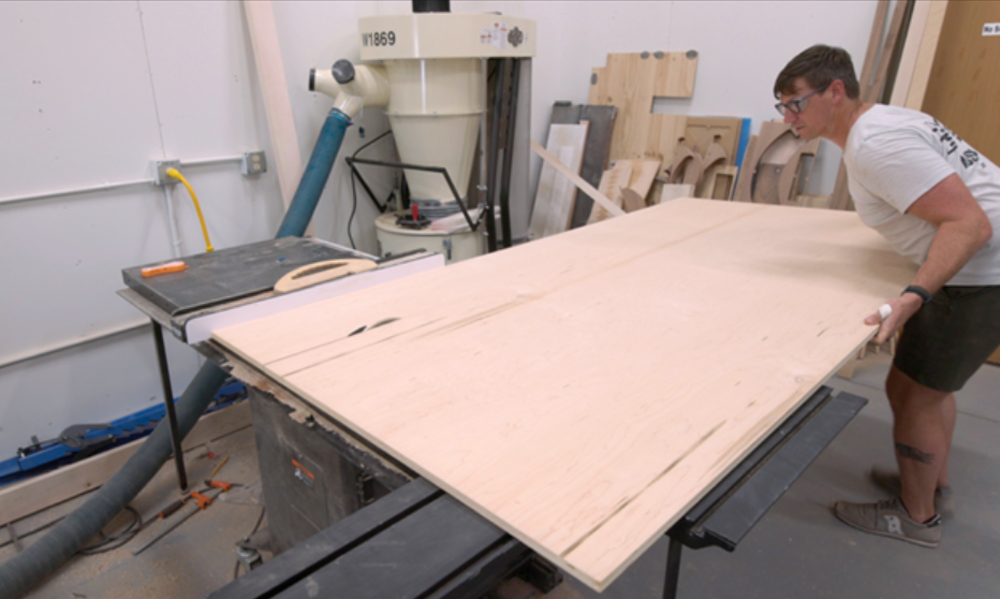 A piece of plywood is being placed onto a flat surface.