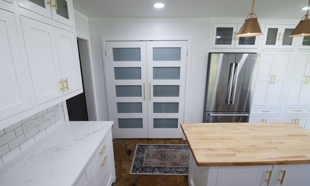 Newly renovated kitchen with white cabinets and gold handles.