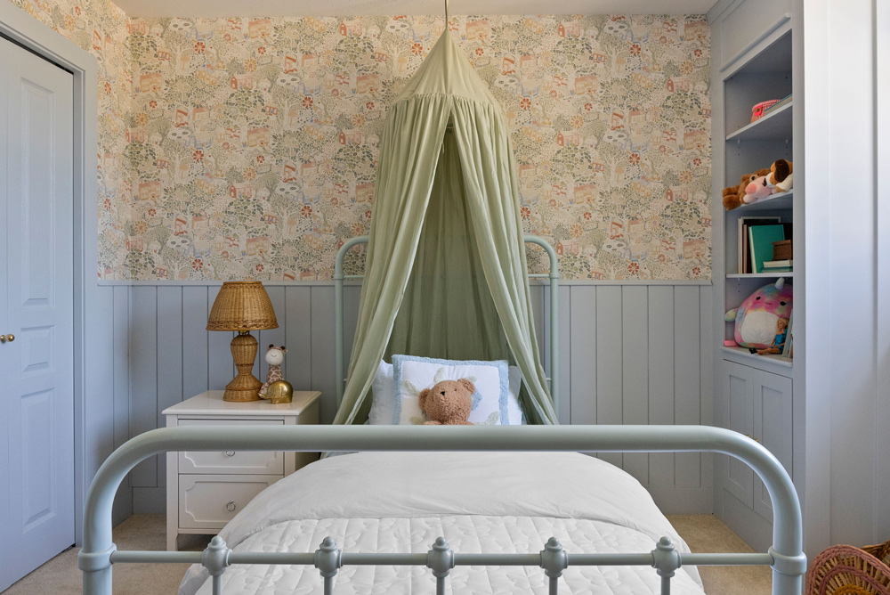 Completely decorated kid’s bedroom with green canopy, floral wallpaper, and bookshelf to the right. Completely decorated kid’s bedroom with green canopy, floral wallpaper, and bookshelf to the right.